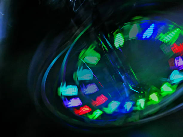 Turning front wheel of a bicycle with colourful LED lighting equipment during long exposure; Blurred motion