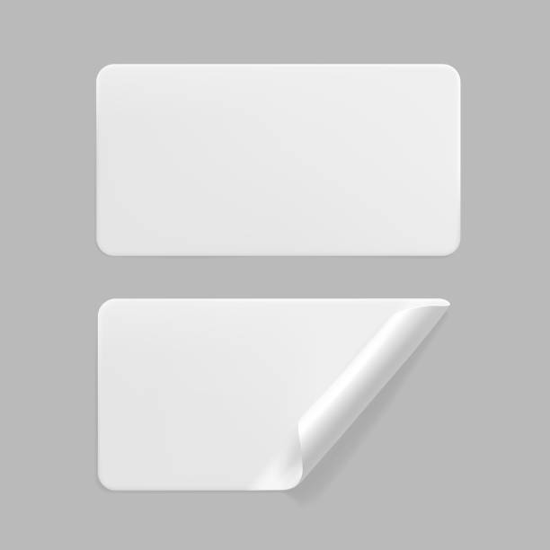 istock White glued rectangle stickers with curled corners mock up set. Blank white adhesive paper or plastic sticker label with wrinkled and creased effect. Template label tags close up. 3d realistic vector 1288610323