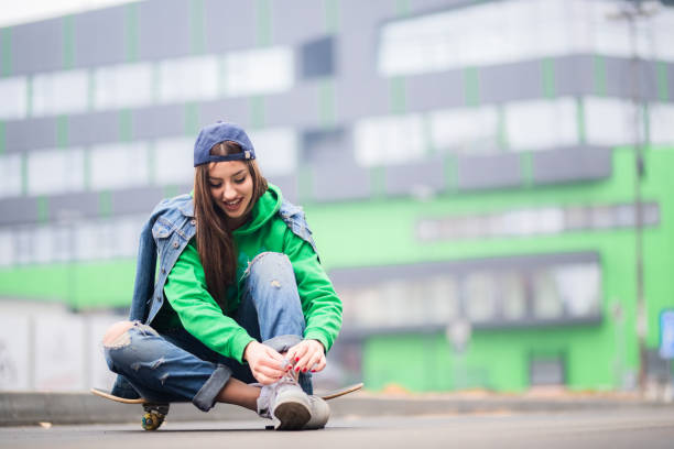 Urban girl is prepairing for skateboard ride stock photo