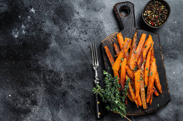 istock Roasted Sweet potatoes stripes. Black background. Top view. Copy space 1288613893