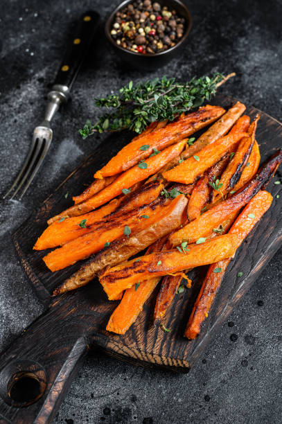 istock Roasted Sweet potatoes stripes. Black background. Top view 1288613951