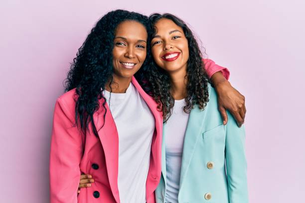 madre e hija afroamericana que llevan estilo de negocios con una sonrisa feliz y fresca en la cara. persona afortunada. - black backgound fotografías e imágenes de stock