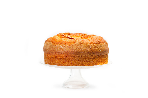 A vanilla cake on a cake stand isolated on a white background