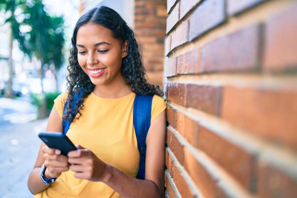 istock Young african american student girl using smartphone at university campus. 1288615356