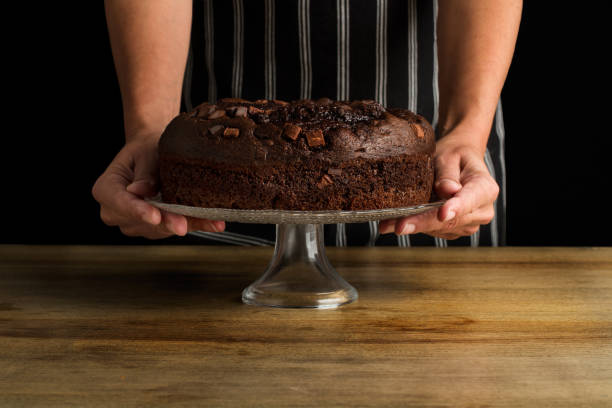 istock Woman holding a cake stand with a chocolate cake 1288615440