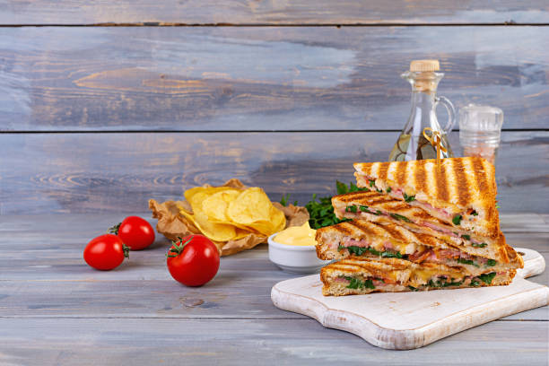 istock Club sandwich with ham, cheese, tomato, salad and chips 1288616389