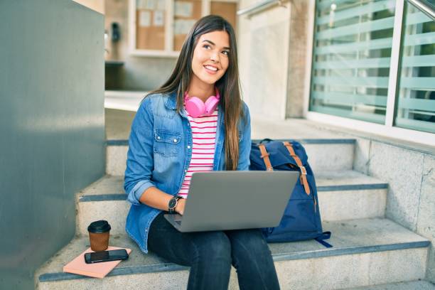 istock Young hispanic student girl smiling happy using laptop at the university. 1288616522
