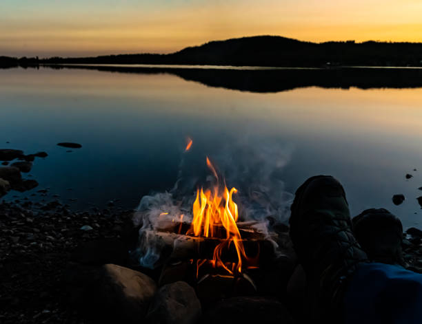 istock Hikers boots resting by a camp fire at the lake. 1288617296