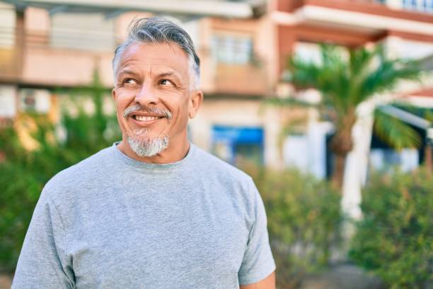 istock Middle age hispanic grey-haired man smiling happy standing at the park. 1288618129