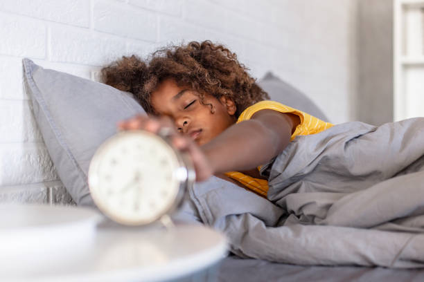 istock Young girl waking up with alarm clock 1288618162