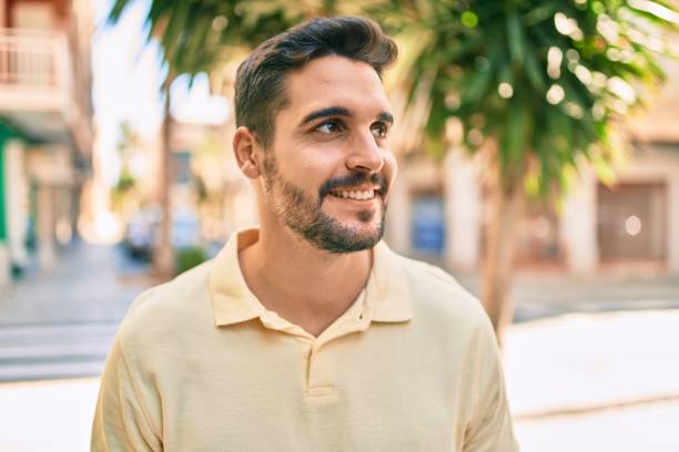 istock Young hispanic man smiling happy walking at the city. 1288618372