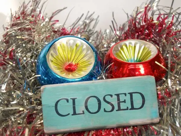 Christmas time decorations with baubles and tinsel and closed sign due to Covid-19 coronavirus lockdown