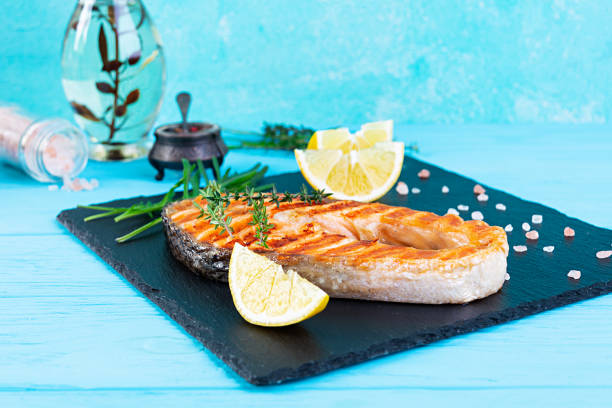 istock Grilled salmon fish on stone board. Salt atlantic salmon fried on grill with lemon 1288618433