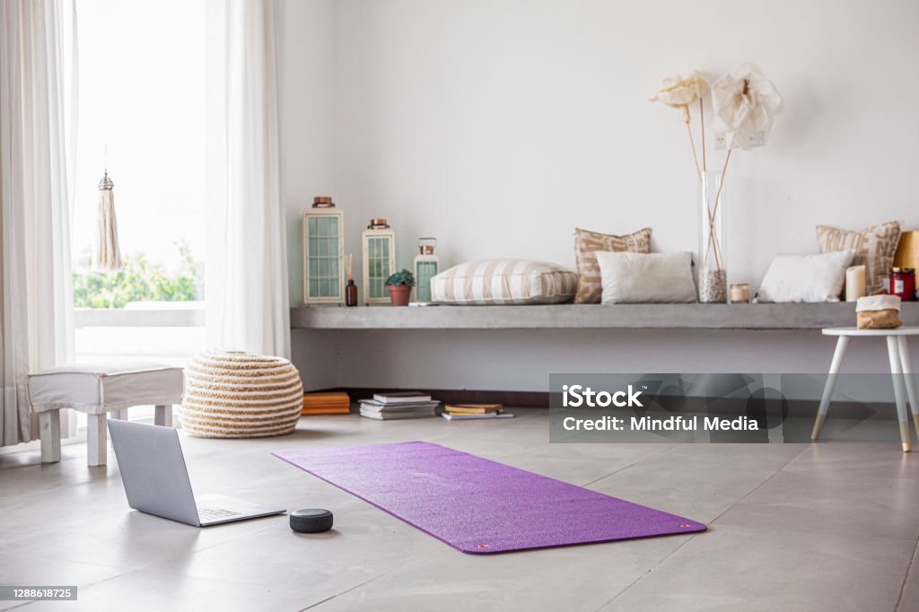 Interior view of living room Interior view of modern living room with laptop exercise mat and smart speaker on floor Exercise Mat Stock Photo