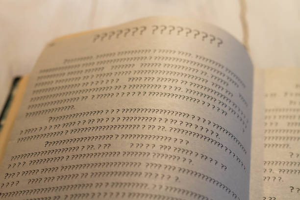 A sheet of book with question marks on the page. The book is open, but there is not a single letter stock photo