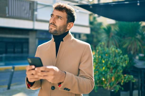 istock Handsome business man wearing elegant jacket using smartphone outdoors 1288622884