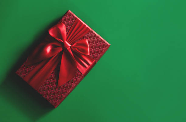 istock Red gift boxes on green background. Christmas card. Flat lay. Top view with space for text. 1288624079