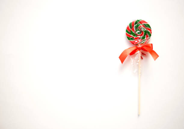 Close up from a Christmas lollypop on a wooden background. Red and white swirl. Background for Christmas.