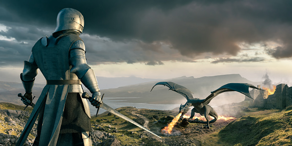 Viewed from behind, a medieval knight shoaled two swords preparing for conflict as he looks down at a large dragon. The fire breathing dragon has wings aloft with grass ablaze behind it. A castle in the background is also on fire. The evening landscape is strewn with rocks and boulders.