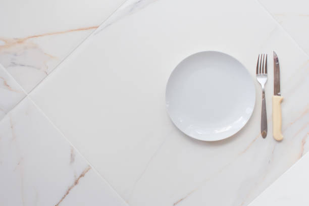 istock Empty ceramics plate isolated on white marble background. Copy space. Menu Recipe Concept 1288625240
