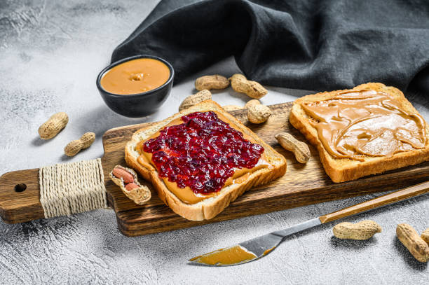 istock Peanut butter and jelly on white bread toasts.  White background. Top view 1288625525