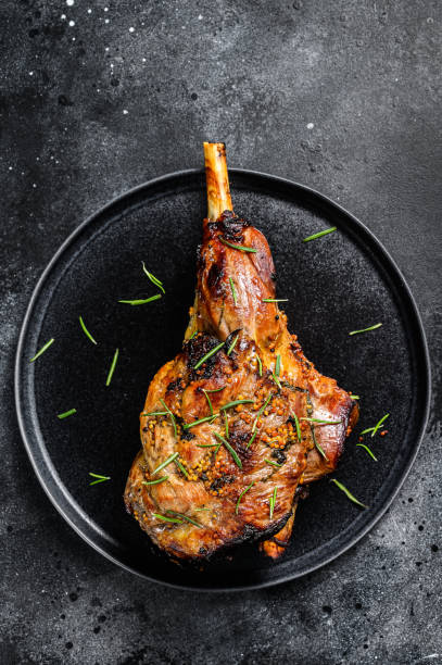 istock Oven baked lamb leg.  Dark background. Top view 1288625562