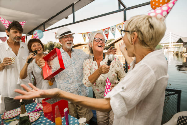 istock Senior people celebrating birthday singing karaoke. 1288626913