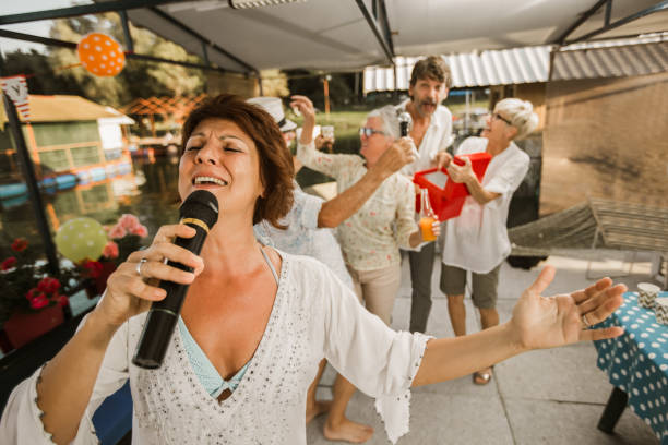 istock Senior people celebrating birthday singing karaoke. 1288628621