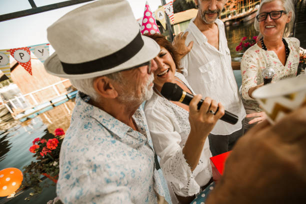 istock Senior people celebrating birthday singing karaoke. 1288628627