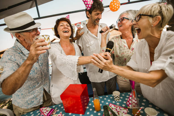 istock Senior people celebrating birthday singing karaoke. 1288629165