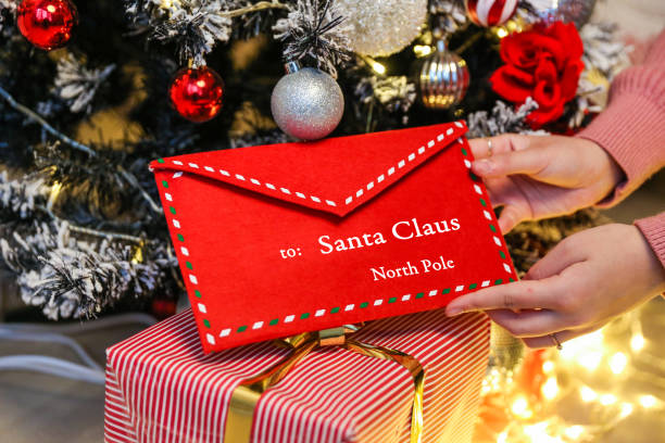 istock hand puts an envelope to santa claus under the christmas tree 1288630265