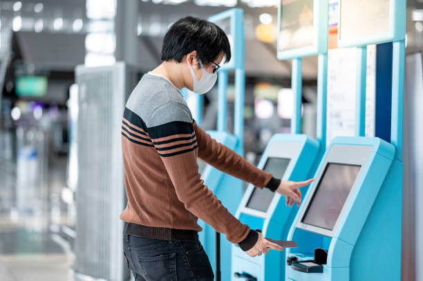 istock Asian man tourist using self check-in kiosk in airport 1288630411