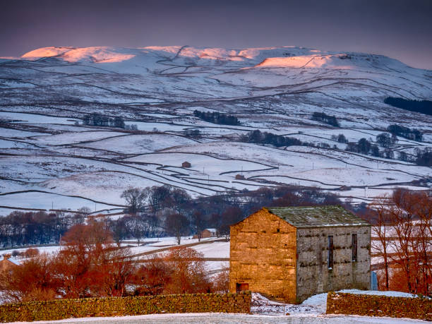 soleil tôt le matin touchant le dessus des collines couvertes de neige avec la grange en pierre, wensleydale, yorkshire dales, yorkshire du nord, angleterre, grande-bretagne - yorkshire dales photos et images de collection