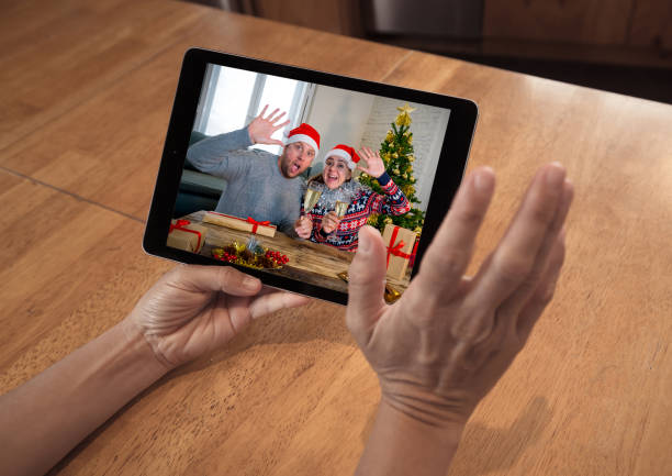 istock COVID-19 Virtual christmas celebration. Screen tablet image with man on video call celebrating virtual christmas in lockdown. Social distancing, quarantine and coronavirus holidays celebrations. 1288631307
