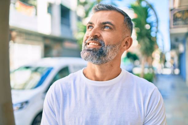 istock Middle age grey-haired man smiling happy standing at the city. 1288631461