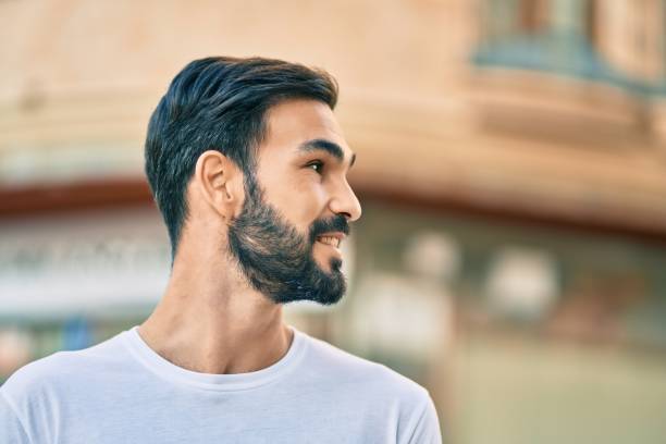 istock Young hispanic man smiling happy standing at the city. 1288632931