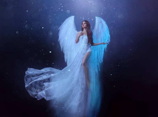 fantasy kobieta anioł wznosi się w powietrzu z białymi ogromnymi skrzydłami ptaków. duch dziewczyna w lewitacji leci. ciemne nocne tło, magiczne światło. bogini lady w białej sukni, tkanina macha trzepotanie w ruchu. - czarodziejki zdjęcia i obrazy z banku zdjęć