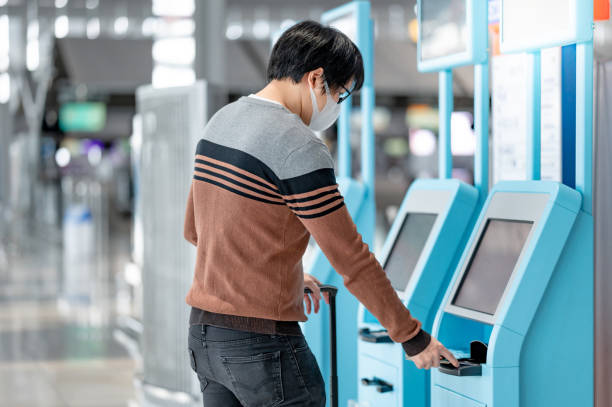 istock Asian man tourist using self check-in kiosk in airport 1288634666
