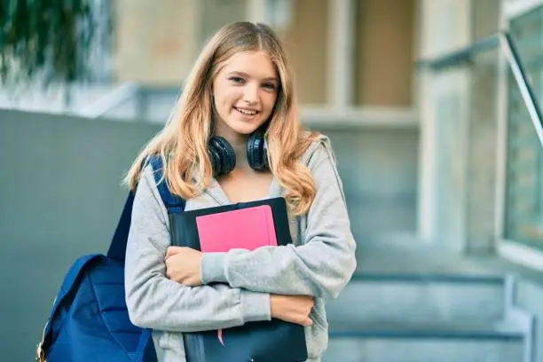 Photo of Beautiful caucasian student teenager smiling happy using headphones at the city.