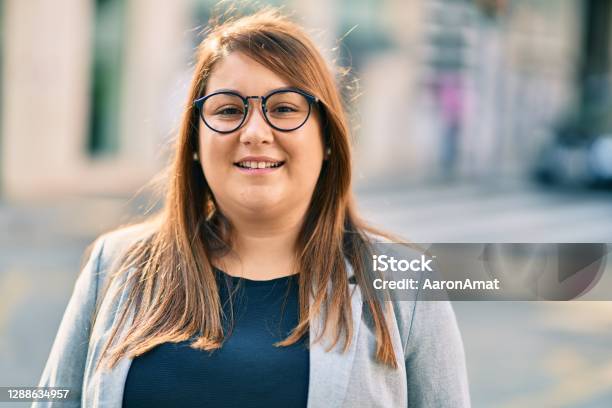 Young Hispanic Plus Size Businesswoman Smiling Happy Standing At The City Stock Photo - Download Image Now