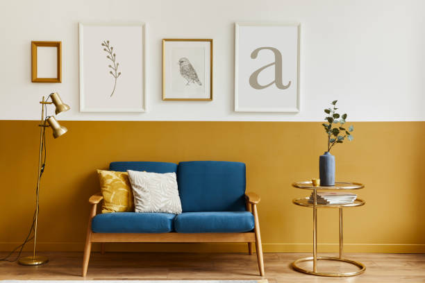 istock Unique living room in modern style interior with design sofa, elegant gold coffee table, mock up poster frames, flowers in vase, decoration and pesronal accessories in home decor. Template. 1288636010