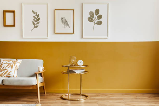 istock Unique living room in modern style interior with design sofa, elegant gold coffee table, mock up poster frames, flowers in vase, decoration and pesronal accessories in home decor. Template. 1288636023