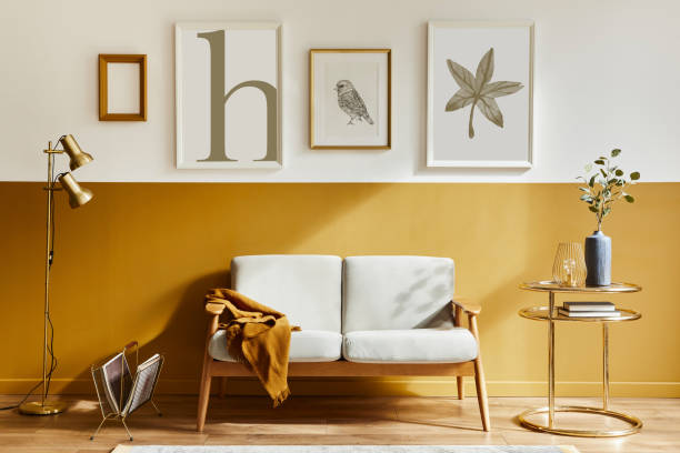istock Unique living room in modern style interior with design sofa, elegant gold coffee table, mock up poster frames, flowers in vase, decoration and pesronal accessories in home decor. Template. 1288636024