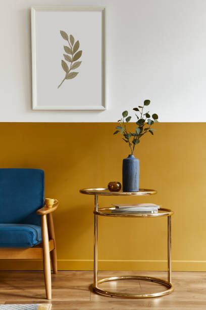 istock Unique living room in modern style interior with design sofa, elegant gold coffee table, mock up poster frames, flowers in vase, decoration and pesronal accessories in home decor. Template. 1288636029