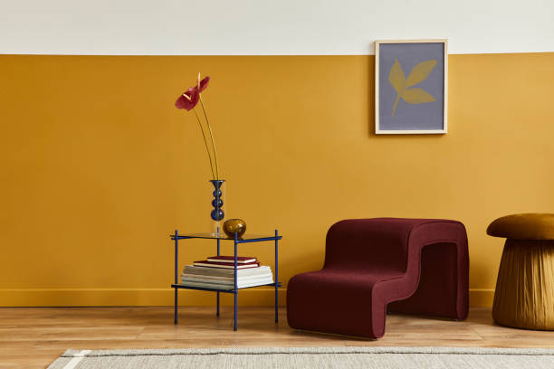 istock Unique living room in modern style interior with design stool, elegant coffee table, mock up poster frame, flowers in vase, decoration and pesronal accessories in home decor. Copy space. Template. 1288636131