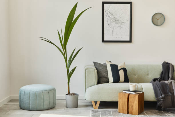 istock Unique loft interior with green comfortable sofa, design furniture, mock up poster map, carpet, plants, decoration and elegant accessories. Modern home decor in living room. White wall. Template. 1288636280