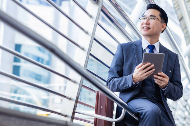 schöne asiatische geschäftsmann hält digitales tablet, anzug und brille. führungskräfte unternehmen erfolgreich werden. männer bekommen vertrauen. professionelle geschäftsmann porträt - digital tablet men male beauty professional occupation stock-fotos und bilder