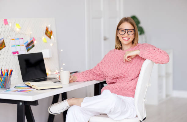 istock Delighted woman resting and looking at camera during work at home 1288637682