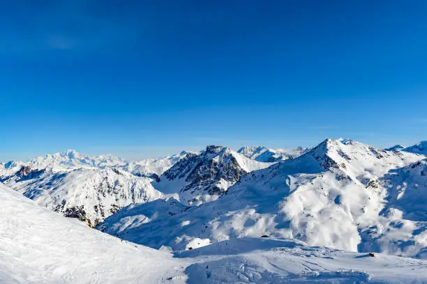 French Alps winter panoramic view high up in the snowy mountains of the Trois Vallees ski area during the winter skiing season near Val Thorens in the Savoie department, France