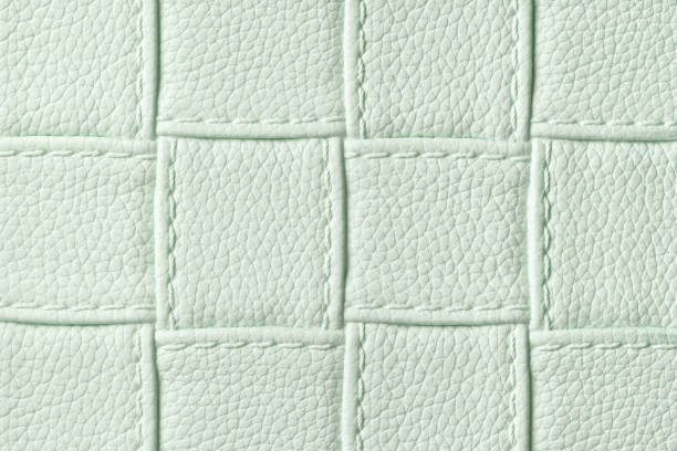 istock Texture of light green leather background with square pattern and stitch, macro. 1288641071
